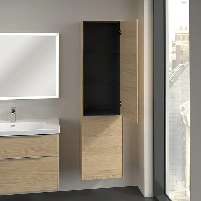 Villeroy & Boch Subway 3.0 Hochschrank - B x T x H: 40 x 36,2 x 171 cm, 1x Klappe mit Wäschekorb, 1x Tür, Nordik oak, Farbe Griff: Aluminium glänzend, DIN Anschlag: Rechts - Badezimmer-Interieur mit einem hellen Holzschrank und einem beleuchteten Spiegel über einem Waschbecken mit Schubladen.