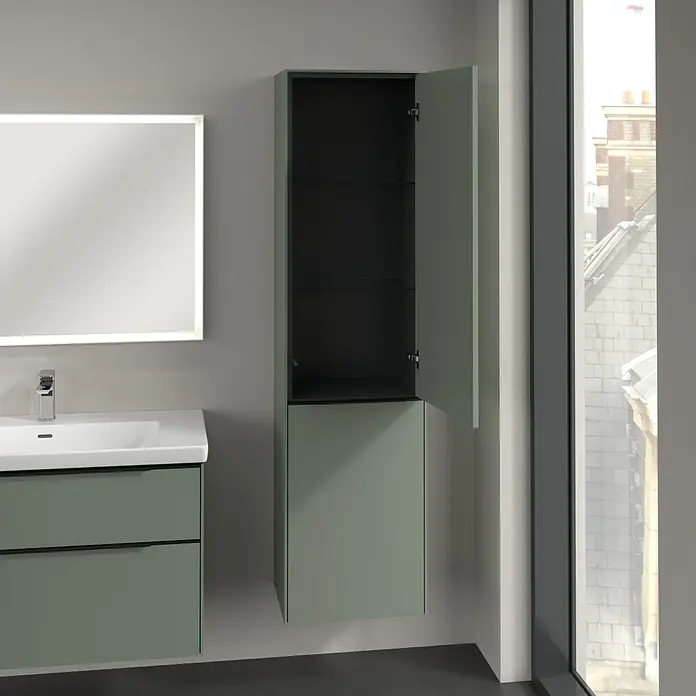 Villeroy & Boch Subway 3.0 Hochschrank - B x T x H: 40 x 36,2 x 171 cm, 1x Klappe mit Wäschekorb, 1x Tür, Soft Green, Farbe Griff: Volcano black, DIN Anschlag: Rechts - Ein Badezimmer mit einem modernen Waschtischunterschrank in Grün, einem beleuchteten Spiegel und einem hoch hängenden Hängeschrank mit offener Tür.