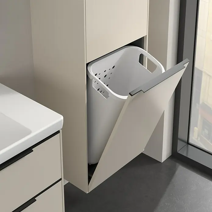 Villeroy & Boch Subway 3.0 Hochschrank - B x T x H: 40 x 36,2 x 171 cm, 1x Klappe mit Wäschekorb, 1x Tür, Cashmere Grey, Farbe Griff: Volcano black, DIN Anschlag: Rechts - Bild eines modernen Badezimmers mit einem ausziehbaren Wäschesammler in einem cremefarbenen Schrank.