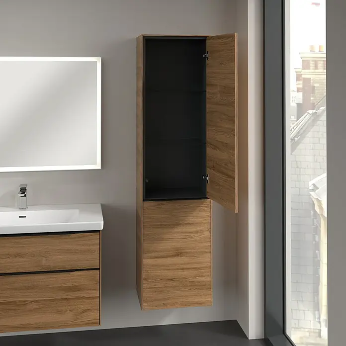 Villeroy & Boch Subway 3.0 Hochschrank - B x T x H: 40 x 36,2 x 171 cm, 1x Klappe mit Wäschekorb, 1x Tür, Kansas Oak, Farbe Griff: Volcano black, DIN Anschlag: Rechts - Badezimmer-Szene mit einem modernen Waschtisch in Holzoptik, einem beleuchteten Spiegel und einem offenen Hochschrank.