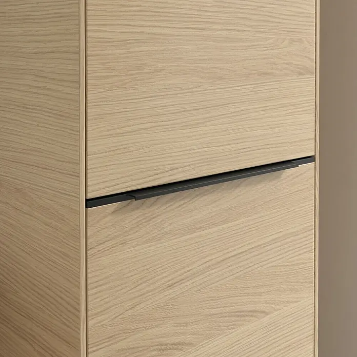 Villeroy & Boch Subway 3.0 Hochschrank - B x T x H: 40 x 36,2 x 171 cm, 1x Klappe mit Wäschekorb, 1x Tür, Nordik oak, Farbe Griff: Volcano black, DIN Anschlag: Rechts - Nahaufnahme eines modernen Holzschranks mit einem eleganten schwarzen Griff, der Funktionalität und minimalistisches Design vereint.