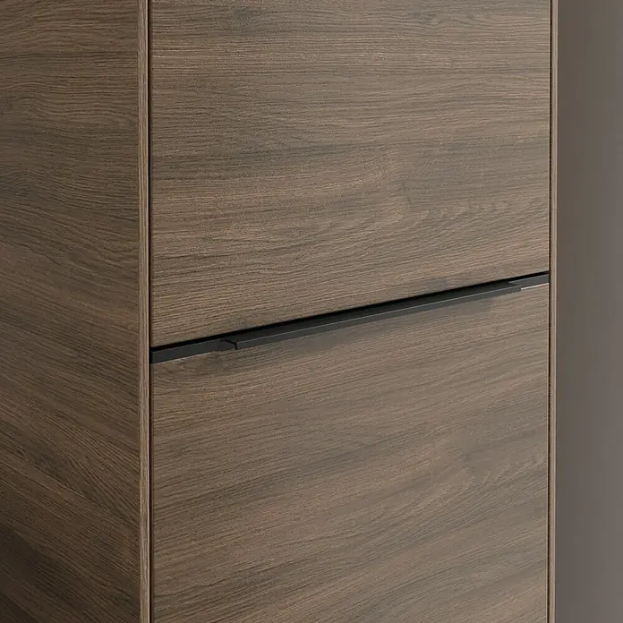 Villeroy & Boch Subway 3.0 Hochschrank - B x T x H: 40 x 36,2 x 171 cm, 1x Klappe mit Wäschekorb, 1x Tür, Arizona Oak, Farbe Griff: Volcano black, DIN Anschlag: Rechts - Nahaufnahme eines modernen Holzschranks mit einem schlichten, schwarzen Griff. Das Holz hat eine deutliche Maserung und eine warme Farbe.