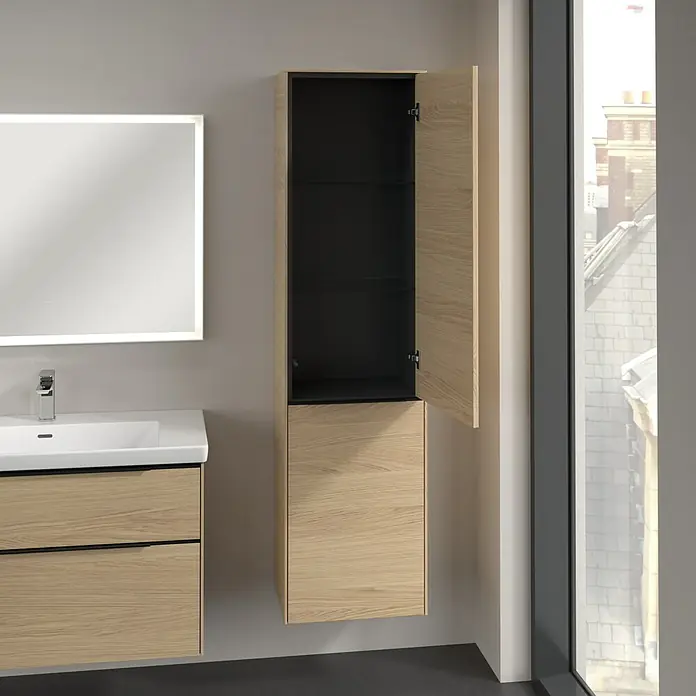 Villeroy & Boch Subway 3.0 Hochschrank - B x T x H: 40 x 36,2 x 171 cm, 1x Klappe mit Wäschekorb, 1x Tür, Nordik oak, Farbe Griff: Volcano black, DIN Anschlag: Rechts - Ein Badezimmer mit einem Waschtisch mit Schubladen und einem hochhängenden Hängeschrank mit offener Tür und Glasböden.