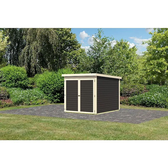 Karibu Fahrradgarage - Holz, Terragrau, Außenmaß inkl. Dachüberstand (B x T): 179 x 227 cm - Eine Gartenhütte mit Doppeltür steht auf einem Pflastersteinplatz, umgeben von üppigem Grün.