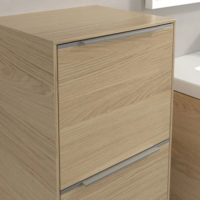 Villeroy & Boch Subway 3.0 Seitenschrank - B x T x H: 40 x 36,2 x 86 cm, Nordik Oak, DIN Anschlag: Links, Farbe Griff: Aluminium glänzend - Nahaufnahme eines hellen Holzschranks mit zwei Schubladen und schlichten silbernen Griffen, der ein modernes Design und eine praktische Aufbewahrungslösung bietet.