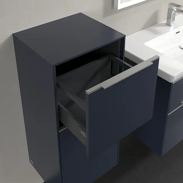 Villeroy & Boch Subway 3.0 Seitenschrank - B x T x H: 40 x 36,2 x 86 cm, Marine Blue, DIN Anschlag: Links, Farbe Griff: Aluminium glänzend - Ein Badezimmerunterschrank in dunklem Blau mit einer Schublade, die teilweise geöffnet ist, und einem weißen Waschbecken mit Armatur.