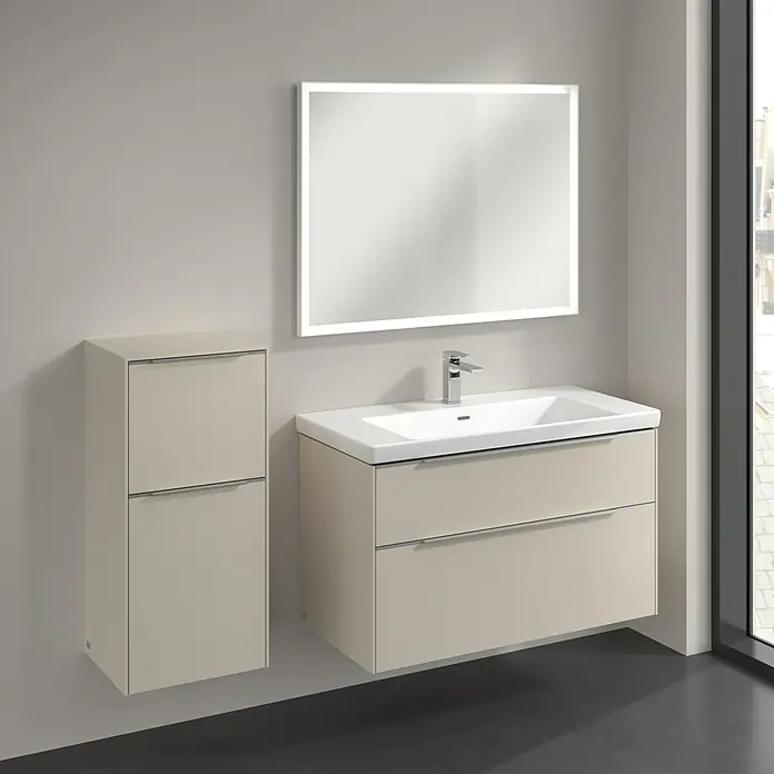Villeroy & Boch Subway 3.0 Seitenschrank - B x T x H: 40 x 36,2 x 86 cm, Cashmere Grey, DIN Anschlag: Links, Farbe Griff: Aluminium glänzend - Ein modernes Badezimmer-Set mit einem beige farbenen Waschtisch mit Schubladen und einem passenden Hochschrank unter einem beleuchteten Spiegel.