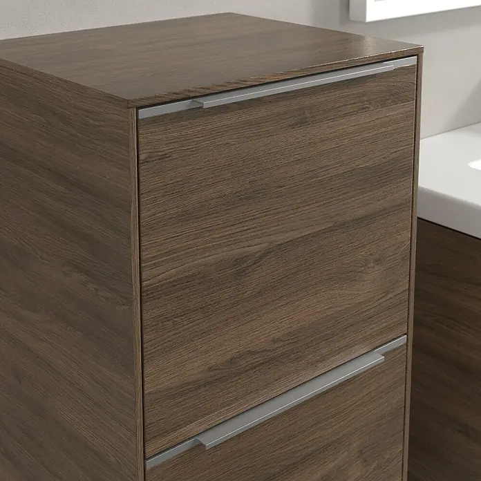 Villeroy & Boch Subway 3.0 Seitenschrank - B x T x H: 40 x 36,2 x 86 cm, Arizona Oak, DIN Anschlag: Links, Farbe Griff: Aluminium glänzend - Nahaufnahme eines modernen Badezimmerschranks mit Holzstruktur und schlanken Metallgriffen, der stilvolle Aufbewahrung bietet.