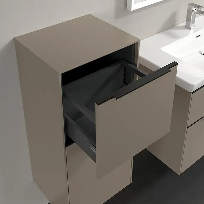Villeroy & Boch Subway 3.0 Seitenschrank - B x T x H: 40 x 36,2 x 86 cm, Taupe, DIN Anschlag: Links, Farbe Griff: Volcano Black - Ein offener Badezimmerschrank mit einer Schublade, die einen Blick auf das Innere des Schranks freigibt, neben einem Waschbecken.