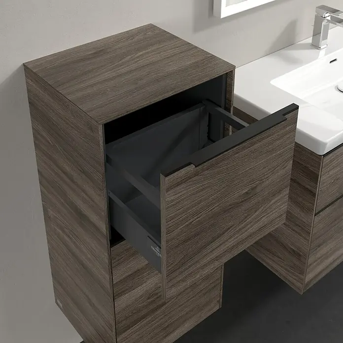 Villeroy & Boch Subway 3.0 Seitenschrank - B x T x H: 40 x 36,2 x 86 cm, Stone Oak, DIN Anschlag: Links, Farbe Griff: Volcano Black - Detailaufnahme eines Waschbeckenunterschranks in Holzoptik mit offenem Schubfach, das modernes Design und Funktionalität vereint.