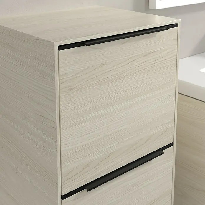 Villeroy & Boch Subway 3.0 Seitenschrank - B x T x H: 40 x 36,2 x 86 cm, White Oak, DIN Anschlag: Links, Farbe Griff: Volcano Black - Ein heller Holzschrank mit zwei Schubladen und schwarzen Griffen, der ein modernes und stilvolles Design zeigt.