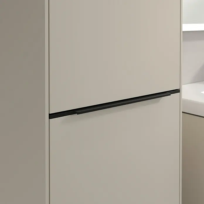 Villeroy & Boch Subway 3.0 Hochschrank - B x T x H: 40 x 36,2 x 171 cm, 1x Klappe mit Wäschekorb, 1x Tür, Cashmere Grey, Farbe Griff: Volcano black, DIN Anschlag: Links - Detailansicht eines eleganten beigen Küchenschranks mit einem schlanken, schwarzen Griff, der modernes Design und Funktionalität vereint.