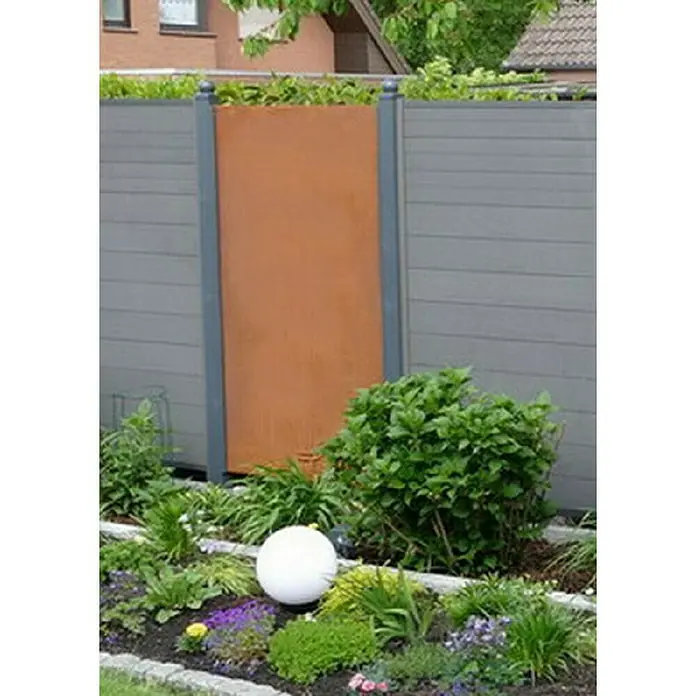 Jabo-Design Sichtschutzelement - 90 x 180 cm, Ohne Dekor, Edelrost - Rostfarbener Sichtschutz aus Metall, eingebettet in eine graue Holzwand, umgeben von üppigem Grün und einer weißen Kugel, die den Garten akzentuiert.