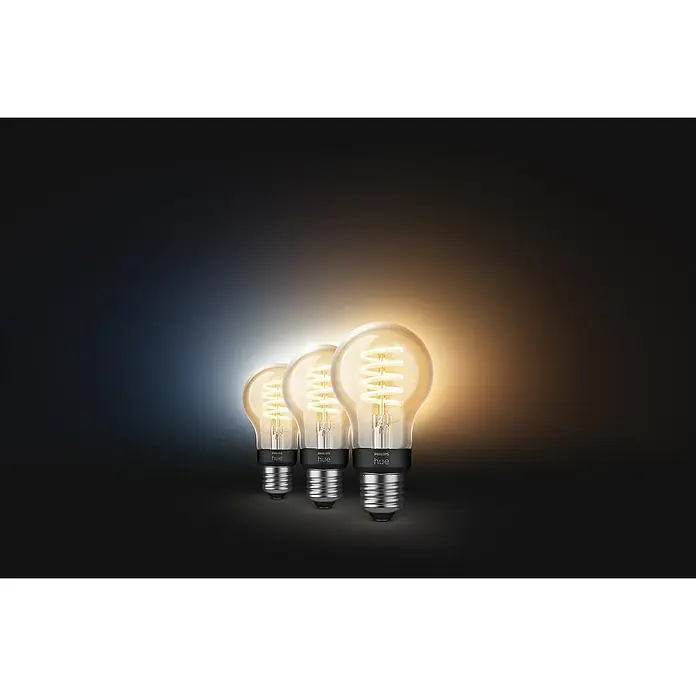 Philips Hue Smart-LED-Lampe White Ambiance Filament - E27, Dimmbar, Warmweiß, 550 lm, 7 W, Lampenbezeichnung: G93, 3 Stk. - Das Bild zeigt drei Philips Hue Glühbirnen mit einem spiralförmigen Glühfaden, die warmes Licht ausstrahlen und eine moderne Atmosphäre schaffen.