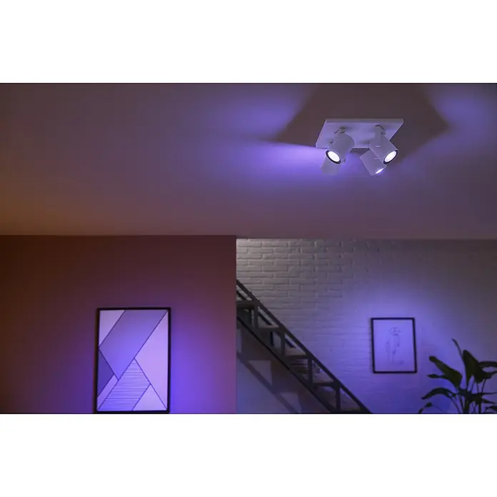 Philips Hue LED-Deckenstrahler White and Color Ambience Argenta - 16,8 W, L x B x H: 24 x 24 x 12,6 cm, Weiß, RGBW, Anzahl Leuchtmittel: 4 Stk. - Deckenleuchte mit drei Strahlern, die ein violettes Licht in einem modern eingerichteten Raum verbreiten.