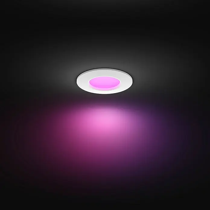 Philips Hue LED-Einbauspot White & Color Ambience Slim Recessed S - 8,3 W, RGBW, Durchmesser: 9 cm, 1 Stk., Weiß - Dieses Bild zeigt eine moderne Deckenleuchte mit einem weissen Rahmen, die in einem dunklen Raum rosa Licht ausstrahlt.