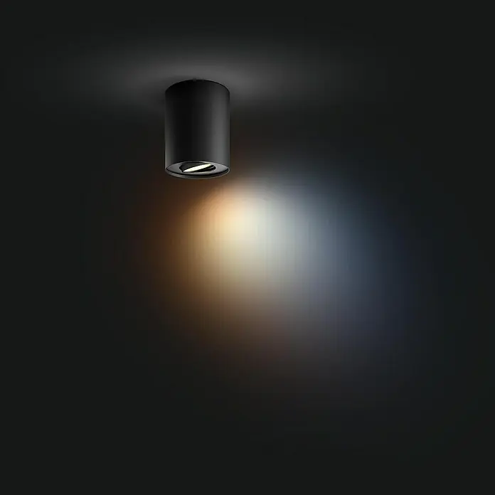 Philips Hue LED-Deckenstrahler White Ambiance Pillar - 4,2 W, L x B x H: 10,3 x 10,3 x 12 cm, Schwarz, Neutralweiß - Schwarze Deckenleuchte an dunkler Decke, die einen Lichtstrahl nach unten wirft.