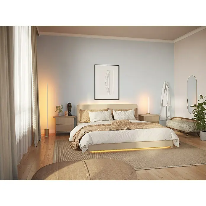 Philips Hue LED-Tischleuchte Signe Oak - 12 W, L x B x H: 11,15 x 11,15 x 55,3 cm, Weiß, RGBW - Ein helles Schlafzimmer mit einem Kingsize-Bett mit integrierter Beleuchtung. Die Nachttische sind mit Lampen dekoriert.