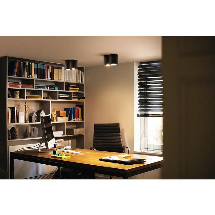 Philips Hue LED-Deckenstrahler White Ambience Pillar - 4,2 W, L x B x H: 19,3 x 10,3 x 12 cm, Weiß, Neutralweiß - Ein modernes Arbeitszimmer mit einem stilvollen Bücherregal, einem Schreibtisch und zwei auffälligen Deckenleuchten für eine angenehme Beleuchtung.