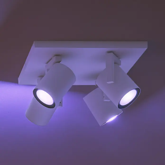 Philips Hue LED-Deckenstrahler White and Color Ambience Argenta - 16,8 W, L x B x H: 24 x 24 x 12,6 cm, Weiß, RGBW, Anzahl Leuchtmittel: 4 Stk. - Nahaufnahme einer weißen Deckenleuchte mit drei Strahlern, die ein angenehmes Licht im Raum verteilen und eine moderne Atmosphäre schaffen.