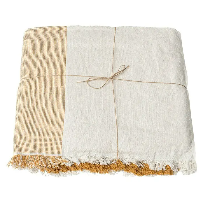 Manta para sofá Raya Centro - Textil, Gold - Manta de cama beige plegada con flecos amarillos atada con hilo de bramante. La manta está decorada con una cuerda clásica anudada.