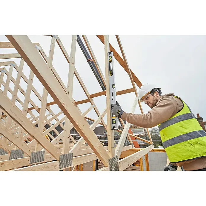 Stanley FatMax Nivel de burbuja Xtreme - Plateado - Un trabajador de la construcción usa un nivel Stanley para asegurarse de que un marco de madera esté alineado. Las herramientas de nivelación Stanley garantizan la precisión.
