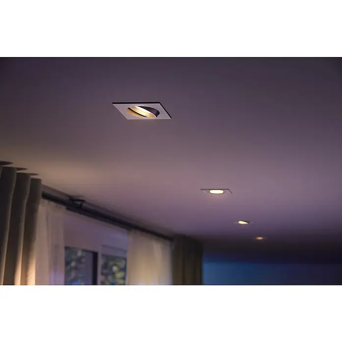Philips Hue LED-Einbauleuchte White and Color Ambience Centura - 4,2 W, L x B x H: 10 x 9 x 9 cm, Weiß, RGBW - Moderne Deckenleuchten mit quadratischer Form in einem Raum mit gedämpftem Licht, die ein gemütliches Ambiente schaffen.