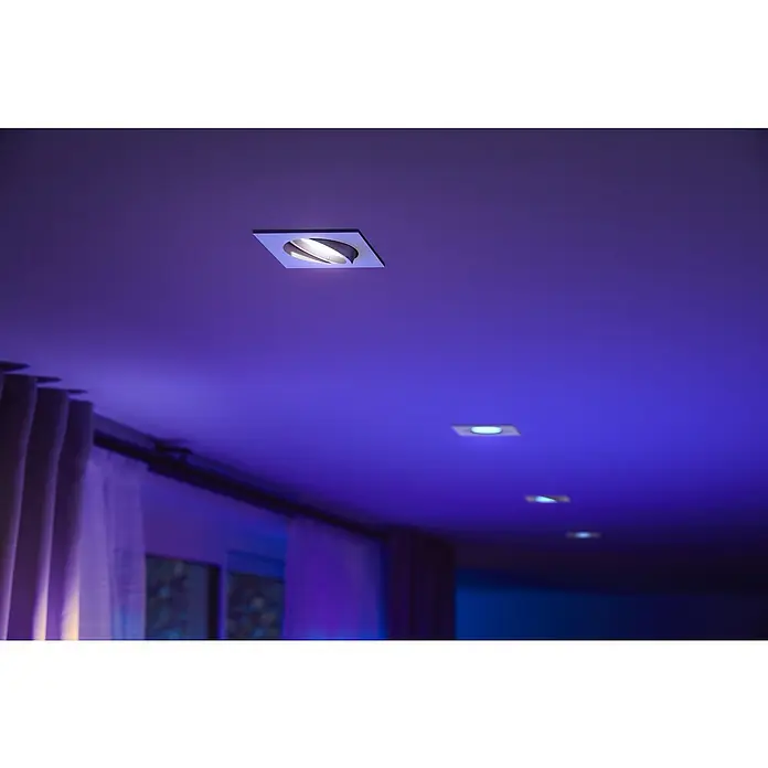 Philips Hue LED-Einbauleuchte White and Color Ambience Centura - 4,2 W, L x B x H: 10 x 9 x 9 cm, Weiß, RGBW - Deckeneinbaustrahler in einem Raum mit stimmungsvoller, farbiger Beleuchtung. Das moderne Design fügt sich nahtlos in die Decke ein.