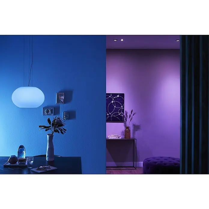Philips Hue LED-Pendelleuchte Flourish - 39,5 W, L x B x H: 40,1 x 40,1 x 30 cm, Weiß - Ein Ambiente-Bild mit einer minimalistischen, runden Hängelampe über einem Tisch mit Dekorationen, alles in beruhigenden Blautönen gehalten.