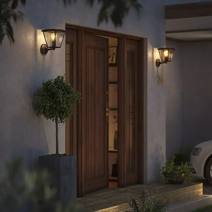 Philips Hue LED-Wandleuchte Inara - 7 W, L x B x H: 21,9 x 22,6 x 27,7 cm, Schwarz, Warmweiß - Nahaufnahme einer Außenwandleuchte, die eine warme und einladende Atmosphäre vor dem Haus erzeugt, während sie gleichzeitig den Eingangsbereich beleuchtet.