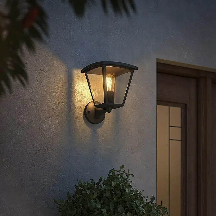 Philips Hue LED-Wandleuchte Inara - 7 W, L x B x H: 21,9 x 22,6 x 27,7 cm, Schwarz, Warmweiß - Nahaufnahme einer schwarzen Außenwandleuchte, die eine warme und einladende Atmosphäre schafft.