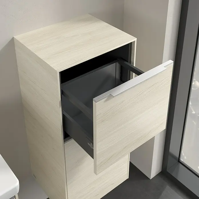 Villeroy & Boch Subway 3.0 Seitenschrank - B x T x H: 40 x 36,2 x 86 cm, White Oak, DIN Anschlag: Rechts, Farbe Griff: Aluminium glänzend - Ein Unterschrank mit einer Schublade in heller Holzoptik, die teilweise geöffnet ist und einen Einblick ins Innere bietet.