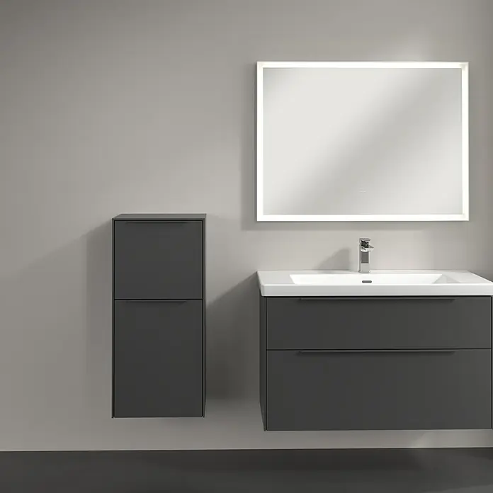 Villeroy & Boch Subway 3.0 Seitenschrank - B x T x H: 40 x 36,2 x 86 cm, Graphite, DIN Anschlag: Links, Farbe Griff: Monochrom - Grauer Badezimmerschrank mit Waschbeckenunterschrank und beleuchtetem Spiegel an grauer Wand.