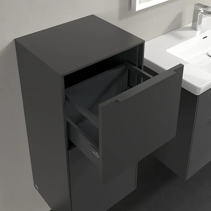 Villeroy & Boch Subway 3.0 Seitenschrank - B x T x H: 40 x 36,2 x 86 cm, Graphite, DIN Anschlag: Links, Farbe Griff: Monochrom - Das Bild zeigt einen modernen grauen Badezimmerschrank mit einer Schublade, die teilweise geöffnet ist, neben einem Waschbecken.