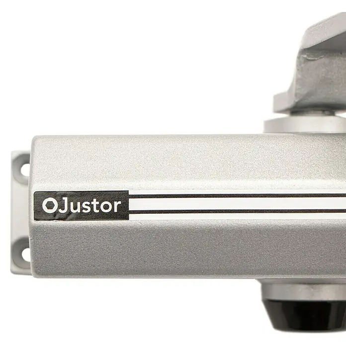 Justor Cerrador de puertas CH - Plateado, Aluminio - Primer plano de un cierrapuertas Ojustor de color plateado con letras negras y placa de montaje.