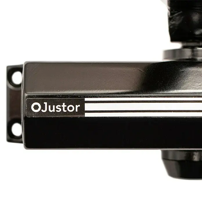 Justor Cerrador de puertas CH - Negro, Aluminio - Detalle de un soporte negro OJustor, que muestra el logotipo de la marca y diseñado para ajustes precisos y montaje seguro en entornos industriales.