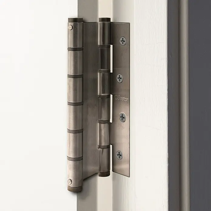 Justor Bisagra DA 180 - L x An x Al: 18 x 15,7 x 2,4 cm, Acero inoxidable - Primer plano de una bisagra de puerta metálica sujeta a una puerta blanca, que muestra su robusta construcción para una funcionalidad fiable.