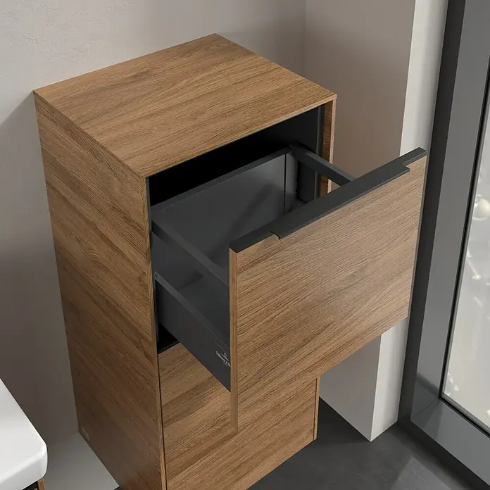 Villeroy & Boch Subway 3.0 Seitenschrank - B x T x H: 40 x 36,2 x 86 cm, Kansas Oak, DIN Anschlag: Rechts, Farbe Griff: Volcano Black - Nahaufnahme eines Badezimmerschranks aus Holz mit einer Schublade, die teilweise geöffnet ist, wodurch der graue Innenraum sichtbar wird.