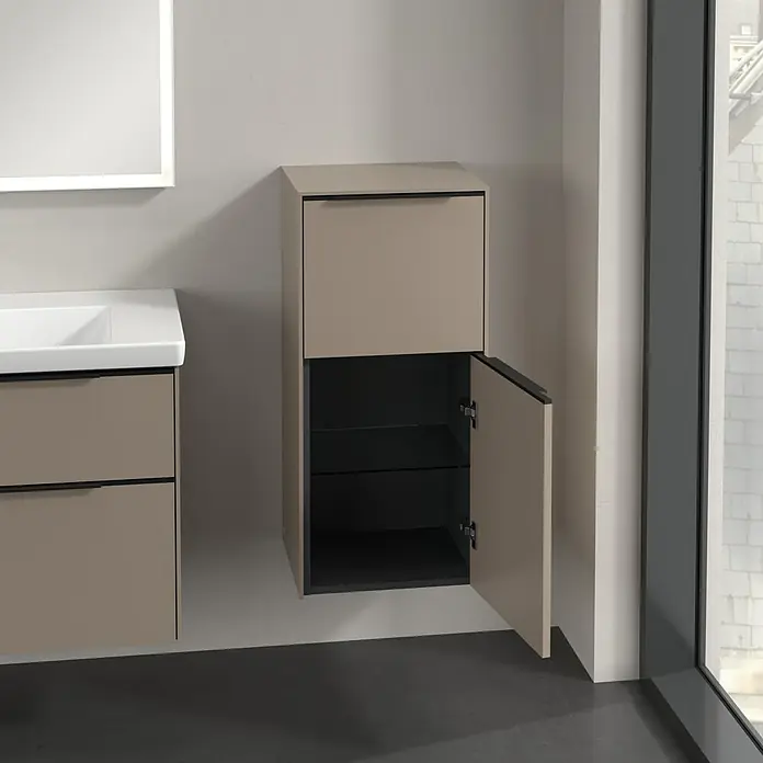 Villeroy & Boch Subway 3.0 Seitenschrank - B x T x H: 40 x 36,2 x 86 cm, Taupe, DIN Anschlag: Rechts, Farbe Griff: Volcano Black - Das Bild zeigt einen modernen Badezimmerschrank in Beige mit einer offenen Tür, die Einblick in die Glasböden gibt.
