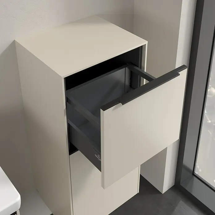 Villeroy & Boch Subway 3.0 Seitenschrank - B x T x H: 40 x 36,2 x 86 cm, Cashmere Grey, DIN Anschlag: Rechts, Farbe Griff: Volcano Black - Das Bild zeigt einen modernen Badezimmerschrank mit einer teilweise geöffneten Schublade, die einen Einblick in das Innere gewährt.