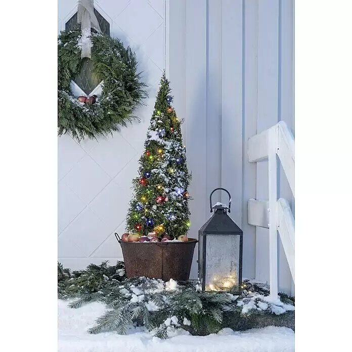 Konstsmide LED-Lichterkette Gefrostet - Außen, Lichtfarbe: RGB, Anzahl Leuchtmittel: 200 Stk., Netzbetrieben, Länge: 41,84 m - Konischer Nadelbaum mit bunten Lichtern in rustikalem Topf mit Äpfeln, schneebedeckte Winterdekoration im Freien.