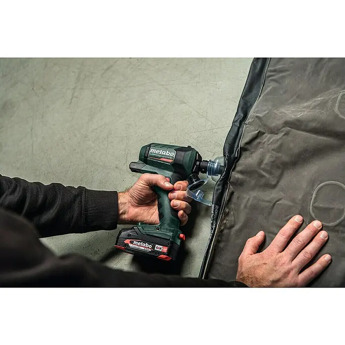 Metabo CAS 18V Akku-Blaspistole BP 18 LTX BL - Ohne Akku, Luftmenge: 0,7 m³/min - Metabo Akku-Schlagschrauber beim Aufpumpen einer Luftmatratze. Der grüne Schrauber mit Akku wird von einer Hand gehalten und ist im Einsatz.