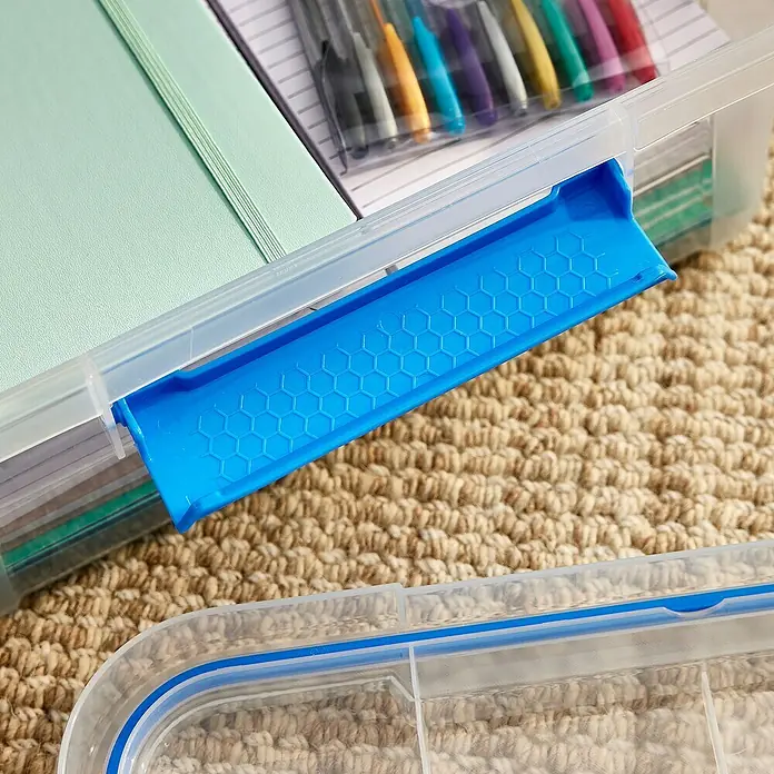 Aufbewahrungsbox Wasserdicht - L x B x H: 38,2 x 28,8 x 15,3 cm, Kunststoff, Transparent - Detailaufnahme einer transparenten Aufbewahrungsbox mit blauem Verschluss, gefüllt mit Stiften und Notizbüchern. Ideal zur Organisation.