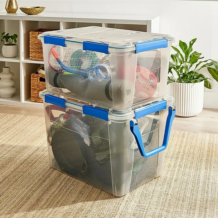 Aufbewahrungsbox Wasserdicht - L x B x H: 64 x 47 x 33,3 cm, Kunststoff, Transparent - Zwei durchsichtige Aufbewahrungsboxen mit blauem Verschluss und Griff, die mit verschiedenen Gegenständen gefüllt sind.