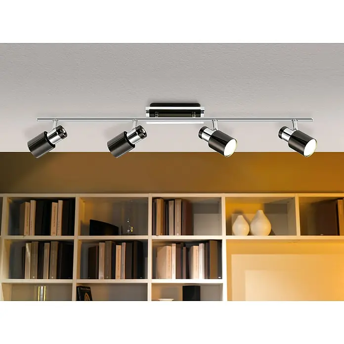 Eglo LED-Deckenleuchte Davida 1 - 20 W, Chrom, Nickel, Schwarz, Warmweiß - Deckenleuchte mit vier Strahlern aus Chrom und Schwarz, die eine moderne Beleuchtung über einem Bücherregal bietet.