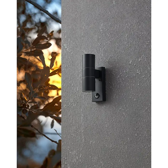 Eglo Außenwandleuchte Riga 5 - 6 W, Schwarz, Anthrazit, Klar, IP44 - Nahaufnahme einer modernen, schwarzen Außenwandleuchte mit Bewegungssensor an einer strukturierten grauen Wand.