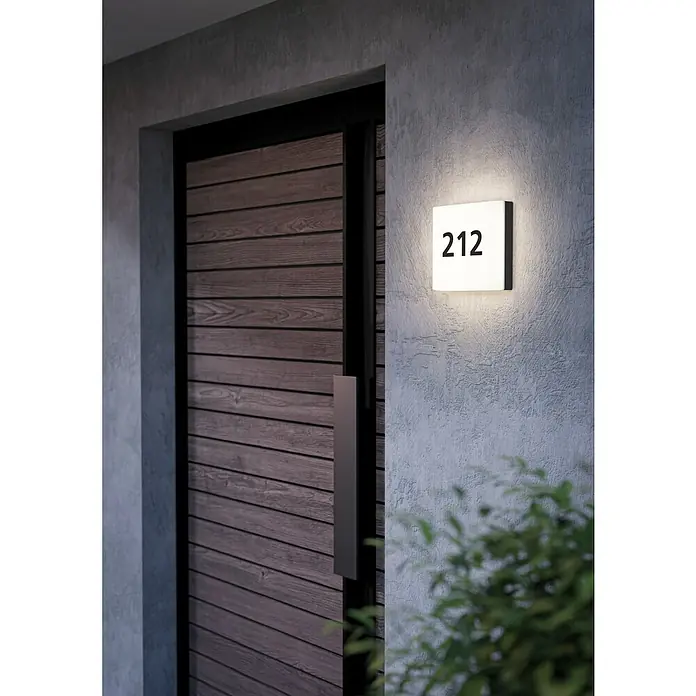 Eglo LED-Außenwandleuchte Cornale - 8,2 W, Schwarz, Anthrazit, Weiß, IP44 - Moderne Hausnummernleuchte neben einer Holztür. Die Leuchte mit der Zahl 212 spendet warmes Licht und ist ein echter Hingucker.
