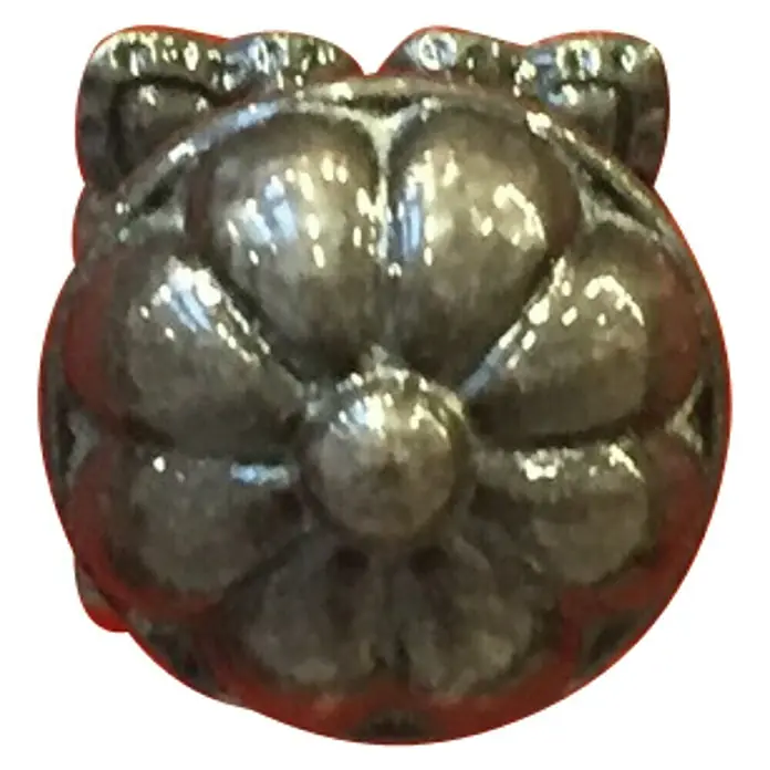 Häfele Pomo para muebles Rústico - Tipo de tirador del mueble: Botón, Negro-Antiguo, Diámetro: 25 mm - Primer plano de un elemento decorativo floral de metal. El diseño decorativo es intrincado y tiene un acabado brillante.
