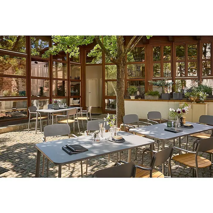 Sunfun Gartenmöbel-Set Gastro II - 5 -tlg., Stahl, Polywood, Night-Grey - Eine Terrasse mit Tischen und Stühlen, die zum Entspannen einlädt. Das Design ist schlicht und modern gehalten.