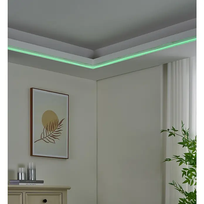 Eglo Connect LED-Stripes Neon-Stripe-Z - 5 cm, Lichtstrom: 3.400 lm, RGBW - Das Bild zeigt ein Zimmer mit indirekter Deckenbeleuchtung, die eine grüne Lichtlinie erzeugt und eine gemütliche Atmosphäre schafft.